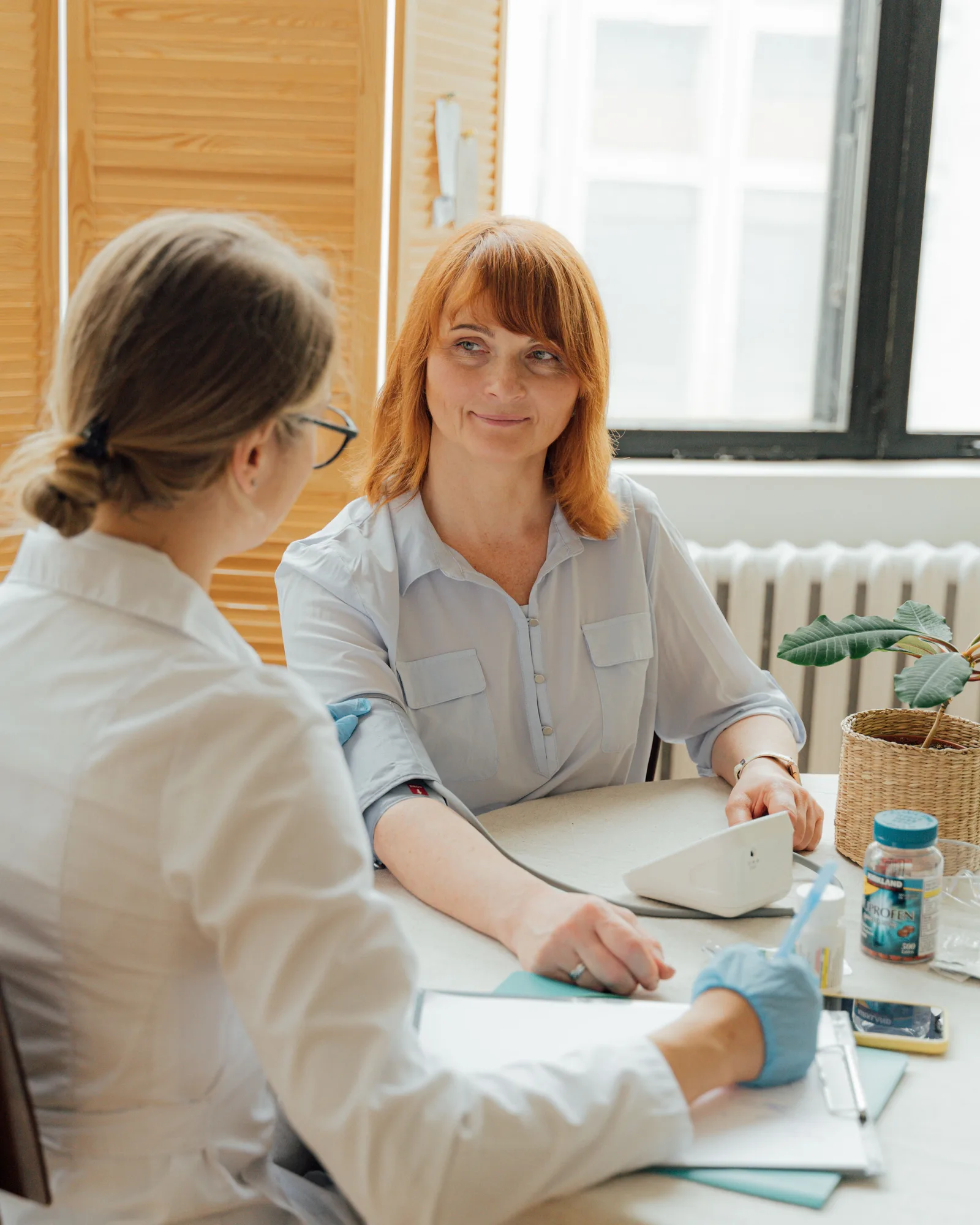 A clinician speaking with an adult in a bright consultation room.